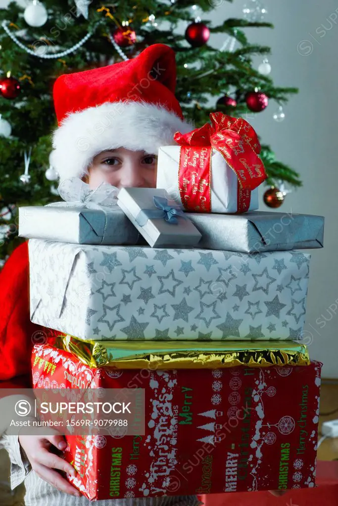 Boy holding stack of Christmas presents