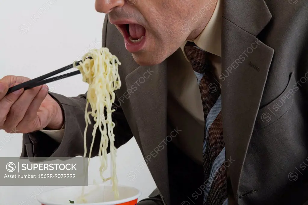 Businessman eating ramen noodles