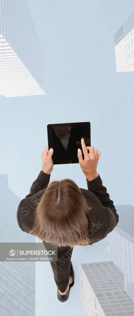 Businesswoman using digital tablet while walking on superimposed image of skyscrapers