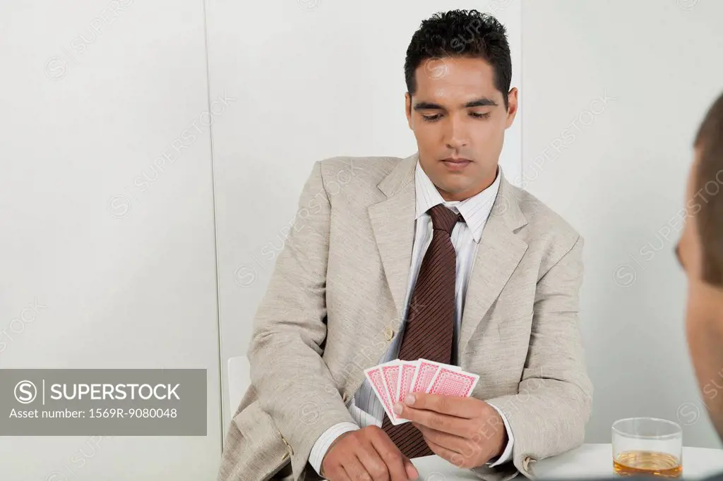 Young businessman playing cards