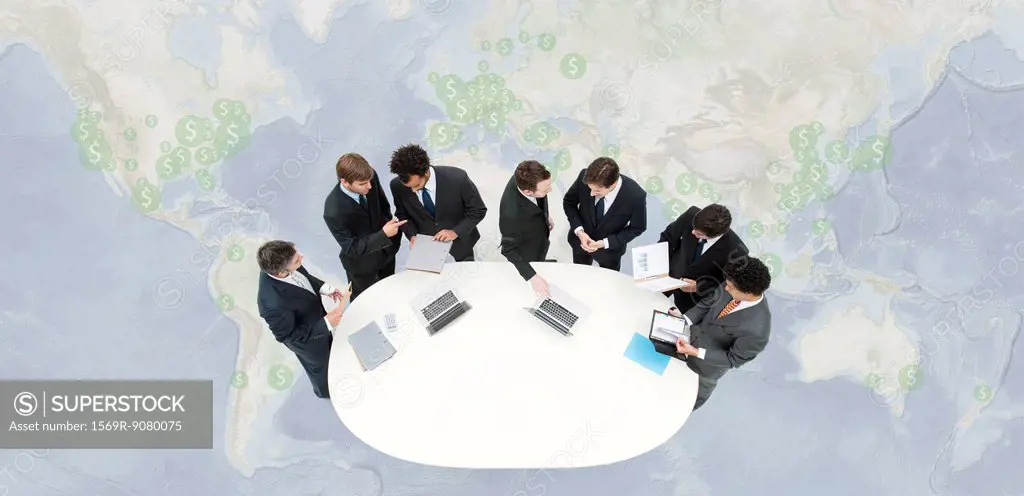 Businessmen in meeting, standing on world map marked with dollar signs