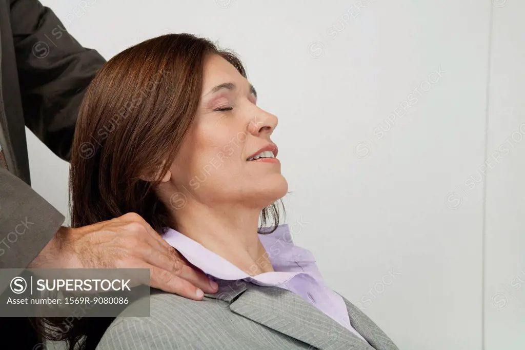 Mature businesswoman having her shoulders massaged