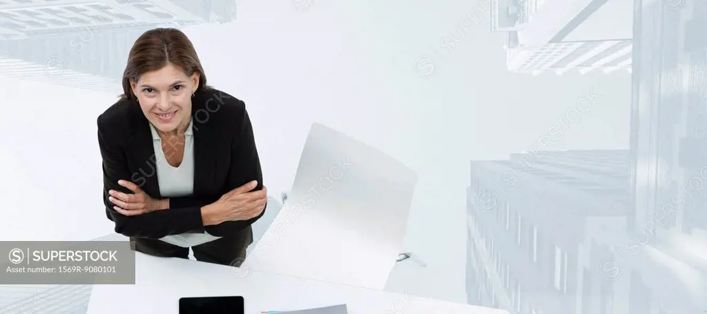 Mature businesswoman smiling confidently with skyscrapers superimposed on background