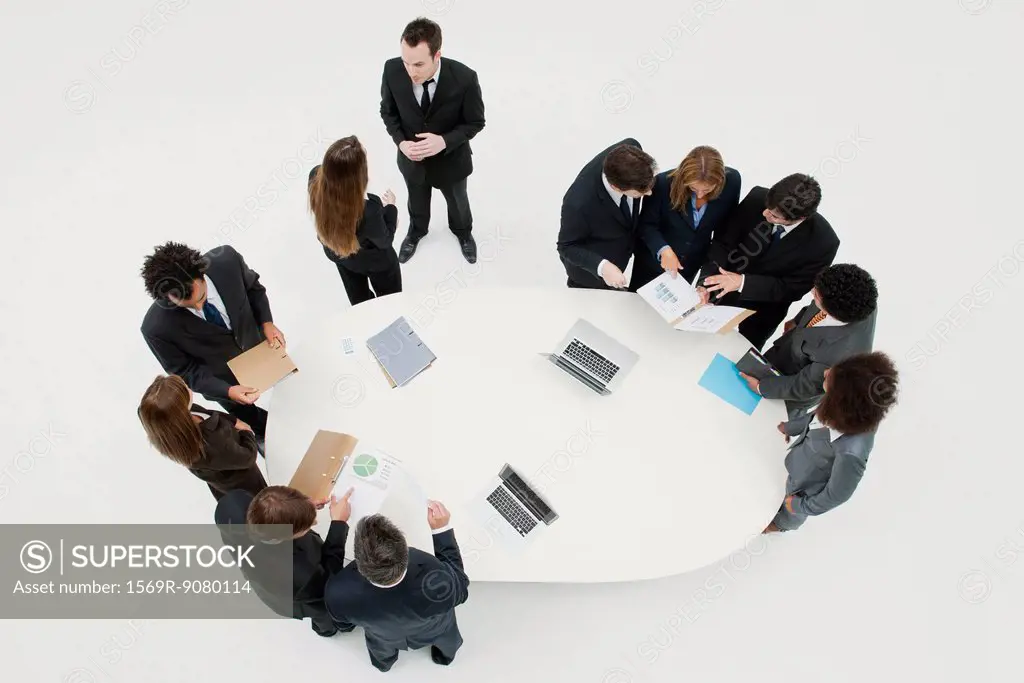 Business associates working together in groups around table