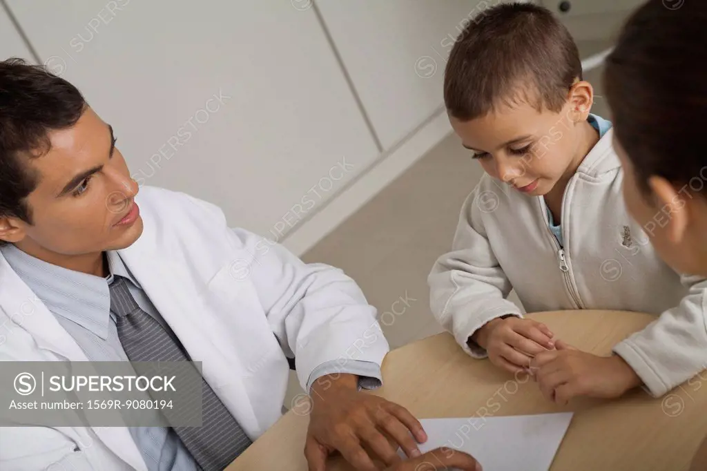 Doctor with little boy and woman