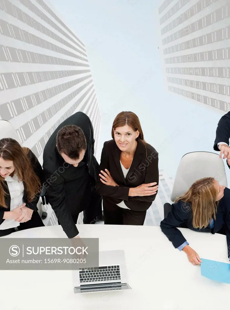 Mature businesswoman meeting with colleagues, skyscrapers superimposed on background