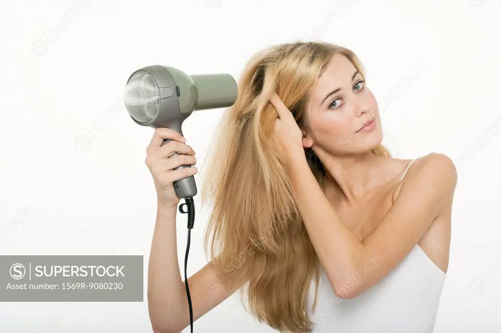 Teen girl using hairdryer