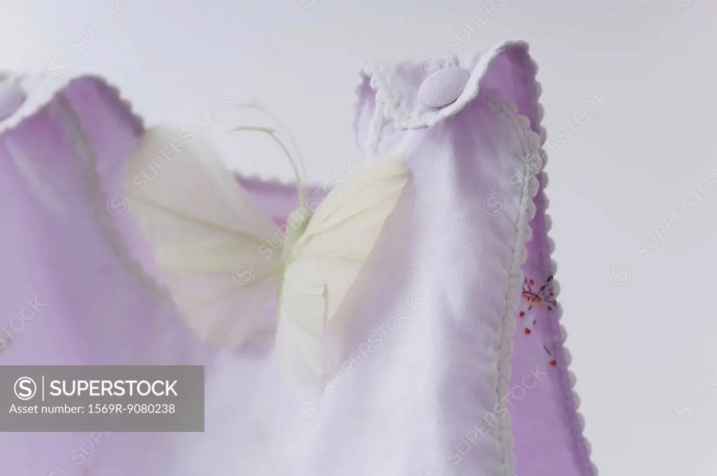 Fake butterfly resting on baby clothing