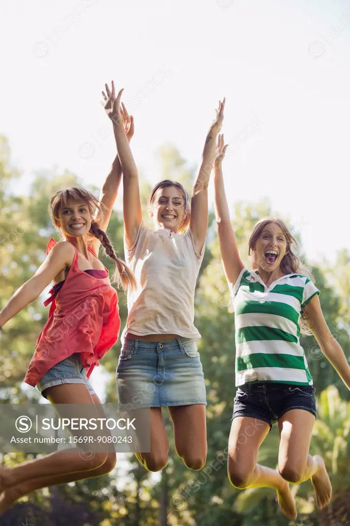 Young women jumping in air, smiling