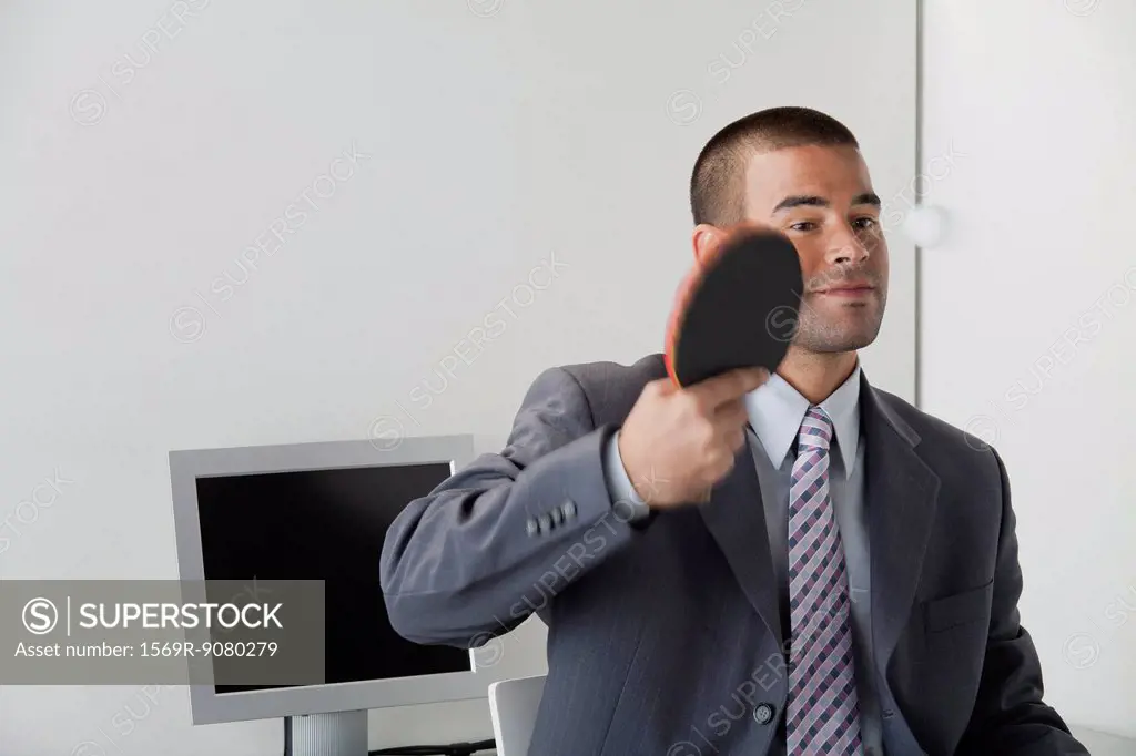 Young man playing table tennis in office