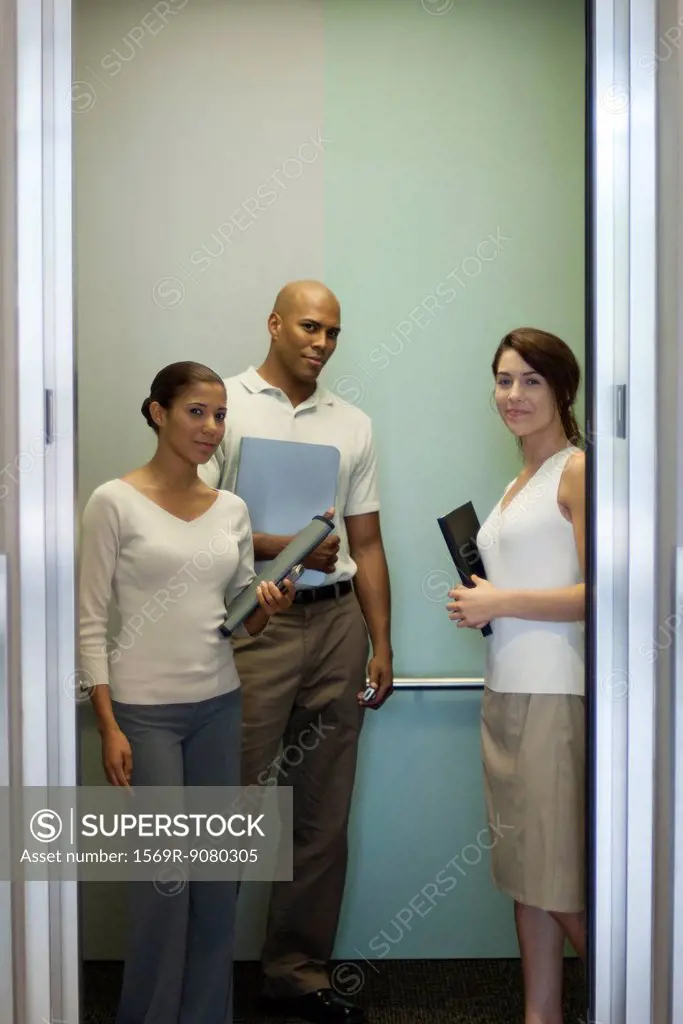 Young office workers standing in elevator