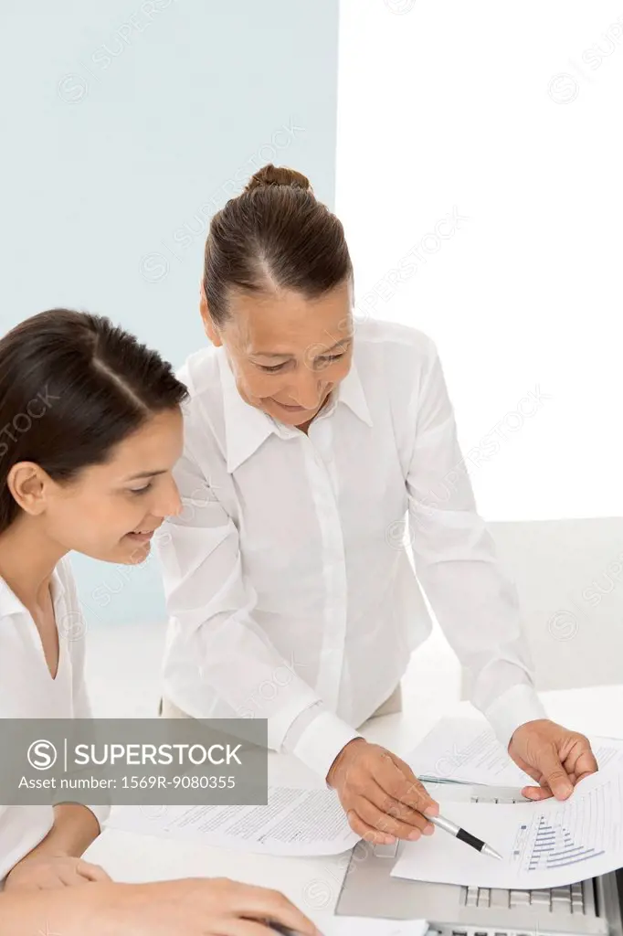 Senior woman assisting young female colleague with work