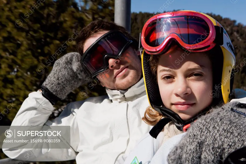 Brother and younger sister on chair lift, portrait