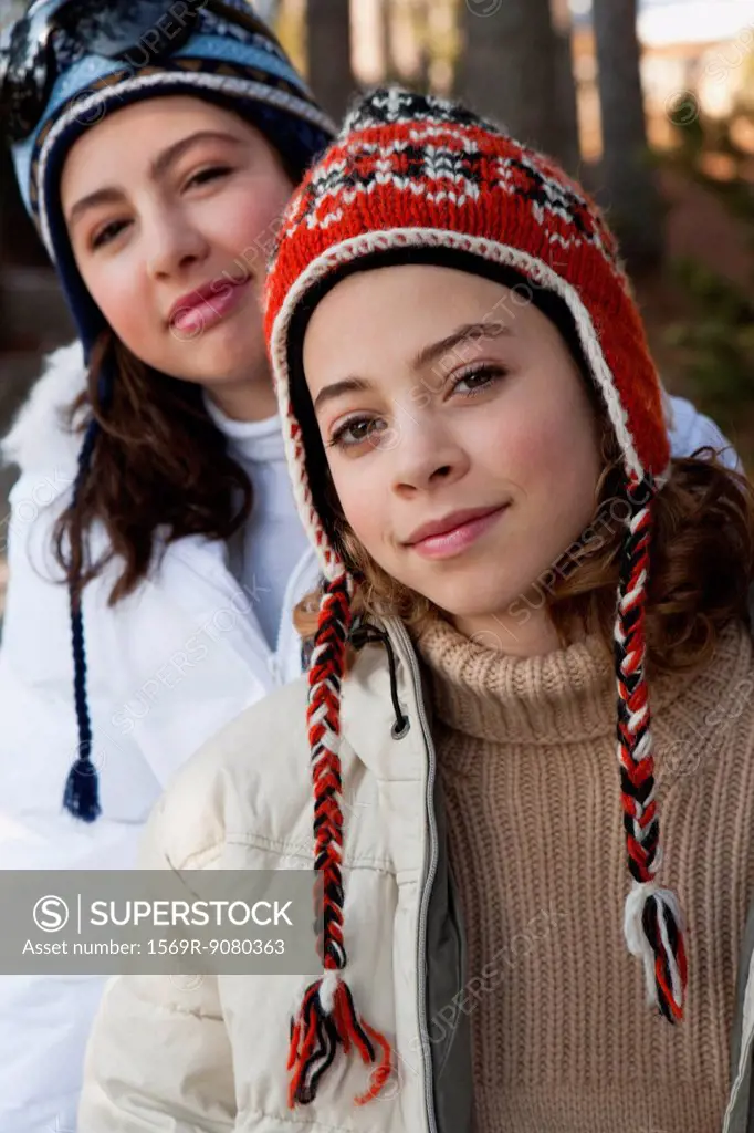 Preteen girl and friend wearing knit hats, portrait