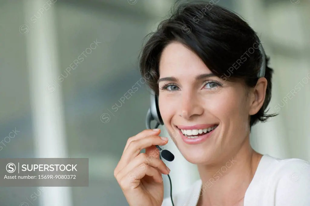 Woman using headset, smiling cheerfully