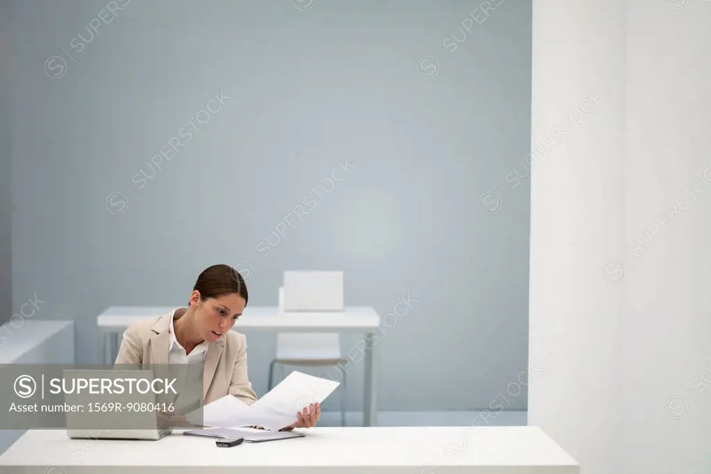 Businesswoman reading documents in office