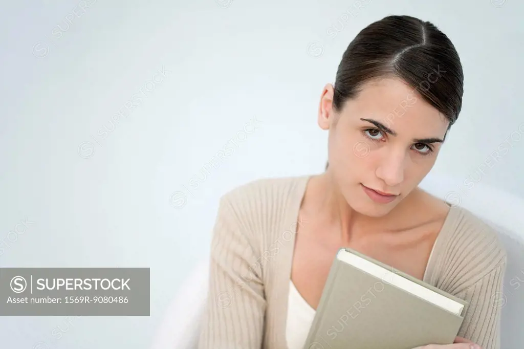 Young woman holding book, portrait
