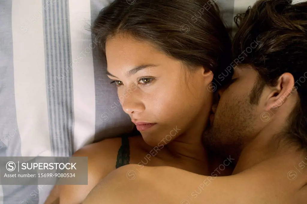 Young couple being intimate in bed, woman looking disinterested