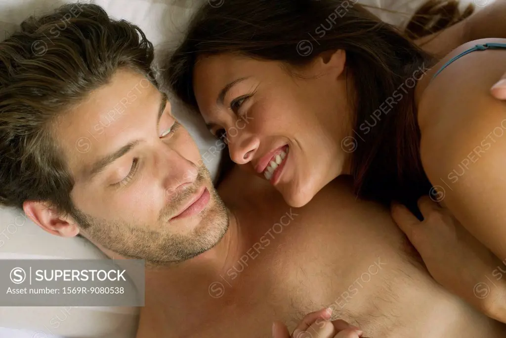 Young couple lying in bed together, directly above
