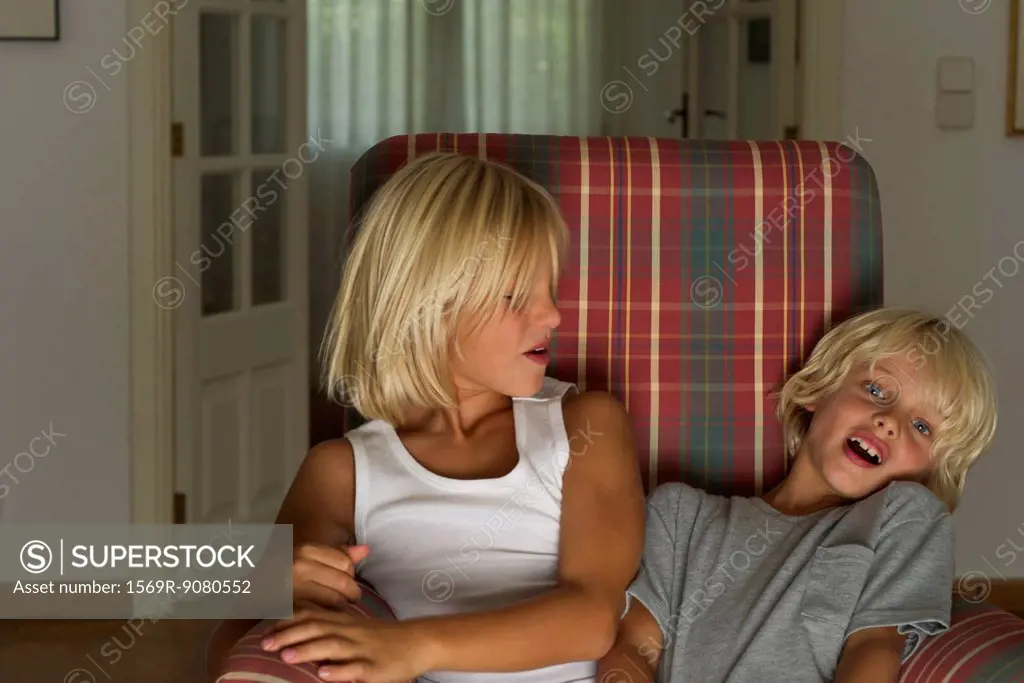 Young brothers sitting together in armchair