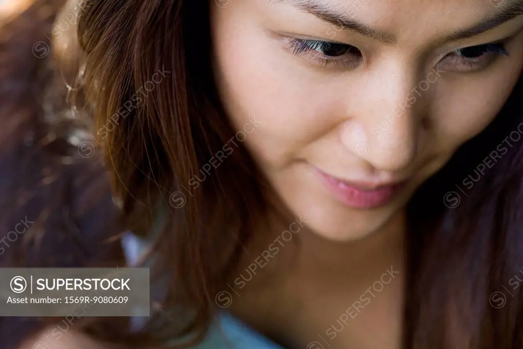 Young woman smiling, looking away in thought