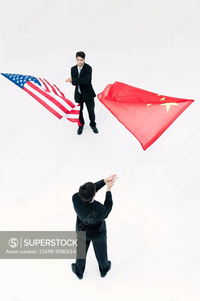 Men standing face to face, waving Chinese and American flags