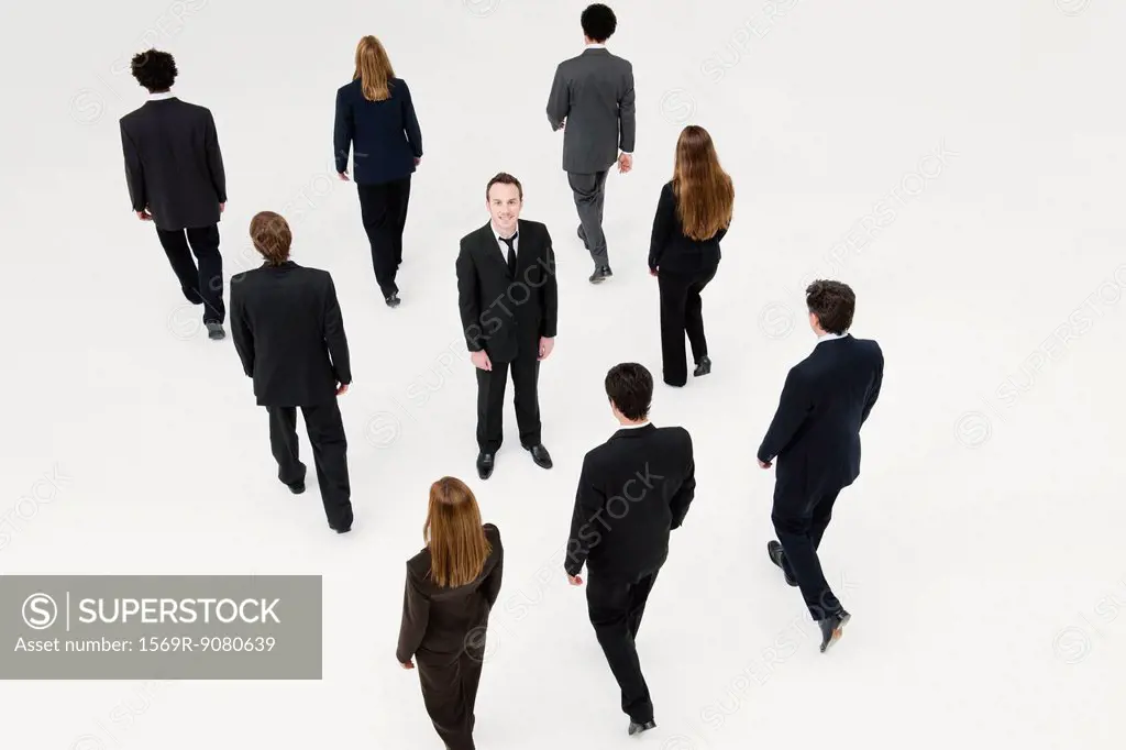 Businessman standing in midst of other anonymously dressed business professionals