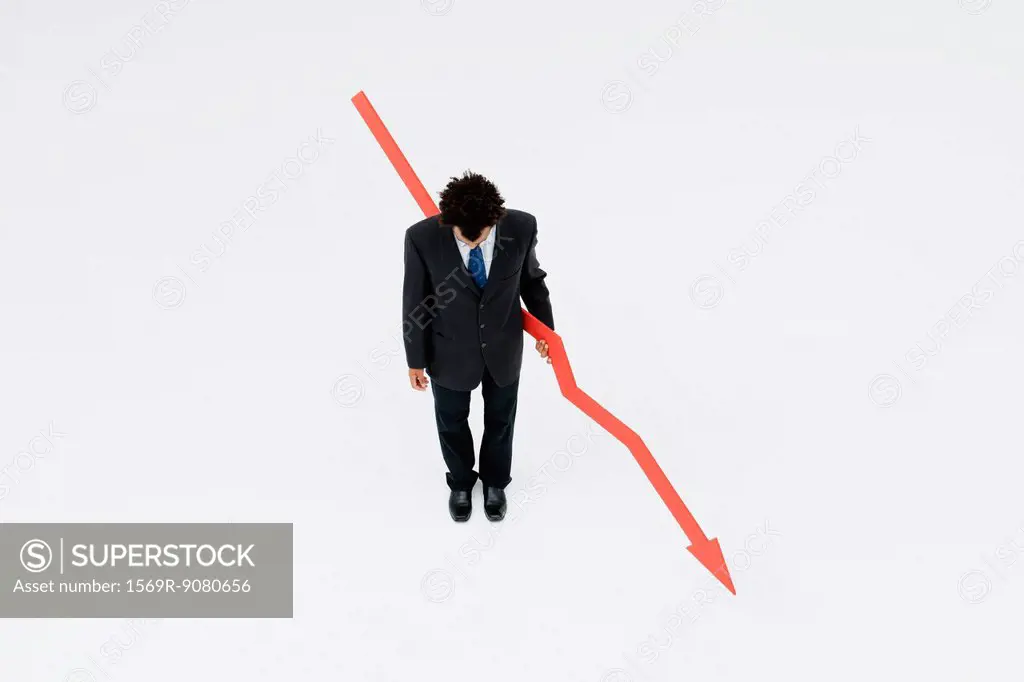 Businessman with arrow pointed downward, projecting financial loss