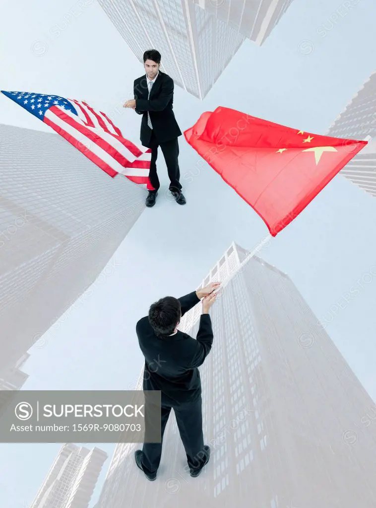 Businessman standing face to face, waving Chinese and American flags