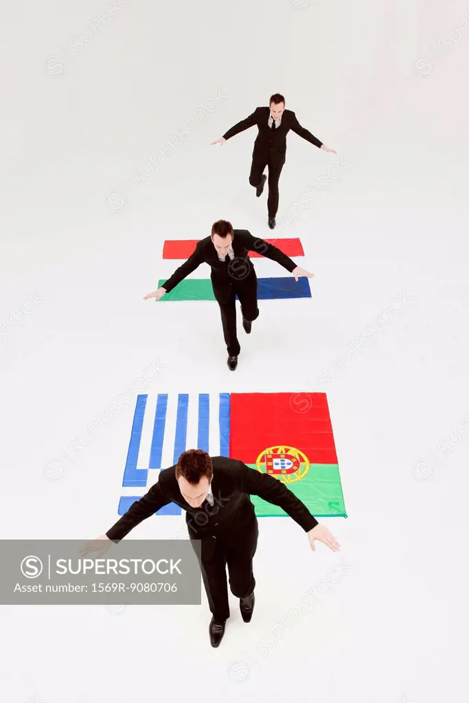 Businessman running across Greek, Portuguese, Italian and French flags