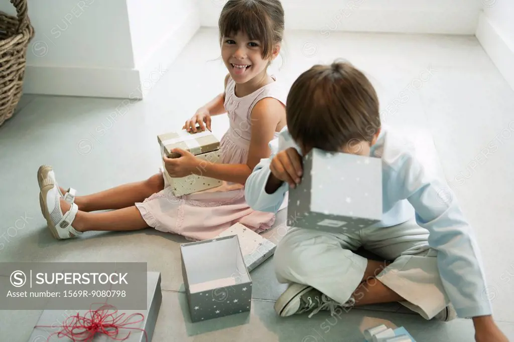 Children sitting on floor opening gifts