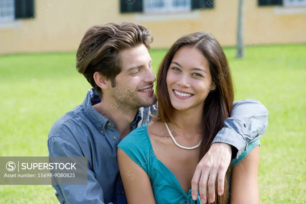 Young man with arm around girlfriend, portrait