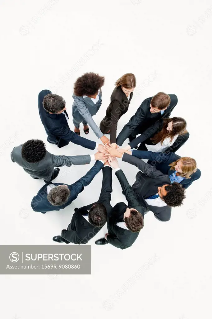 Business associates standing in circle with hands clasped in motivational exercise