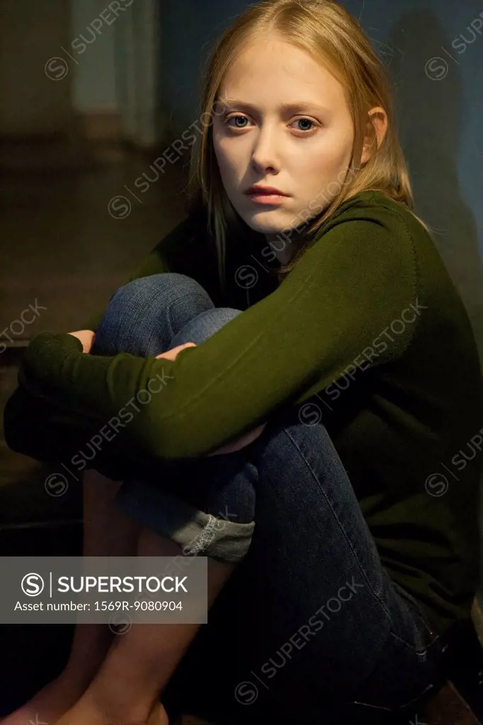 Young woman hugging knees, portrait
