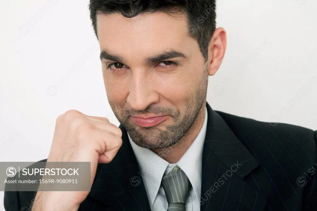 Mid-adult businessman clenching fist, smiling