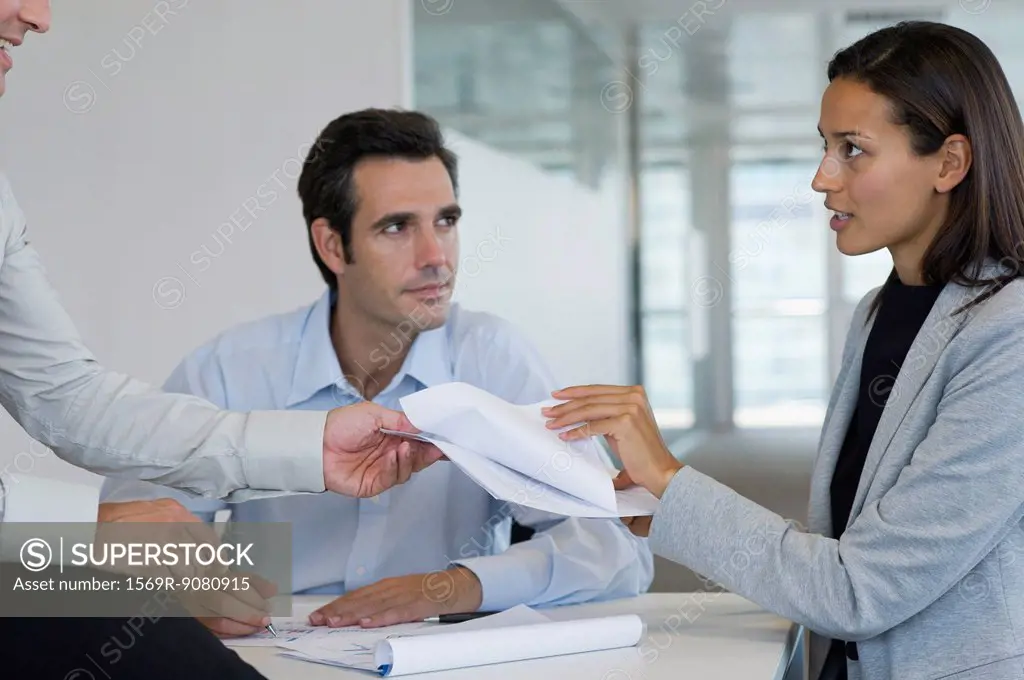 Colleagues discussing documents in meeting