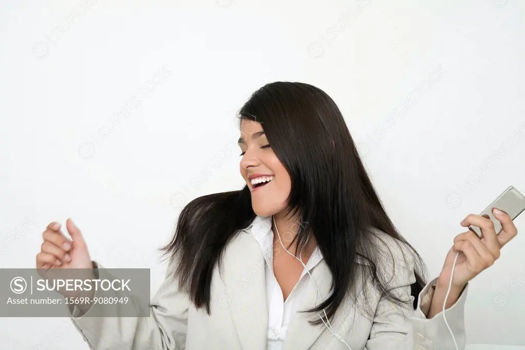Young businesswoman listing to music on mp3 player