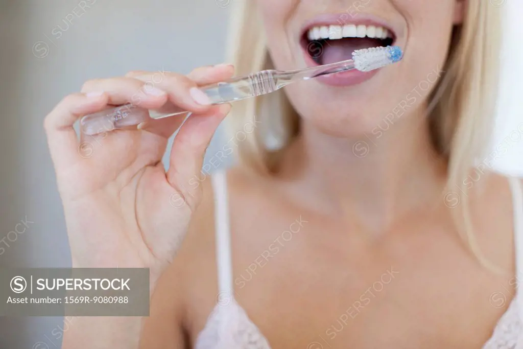 Woman brushing her teeth, cropped