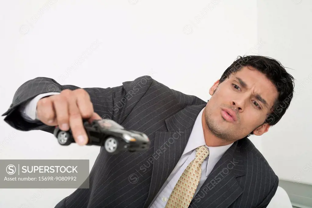 Mid-adult businessman playing with toy car