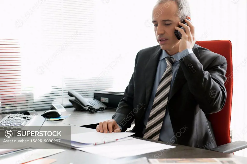 Business executive talking on cell phone in office