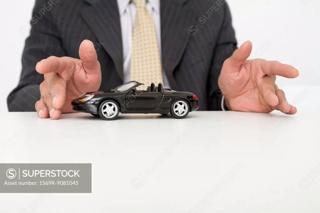 Businessman and toy car, mid section