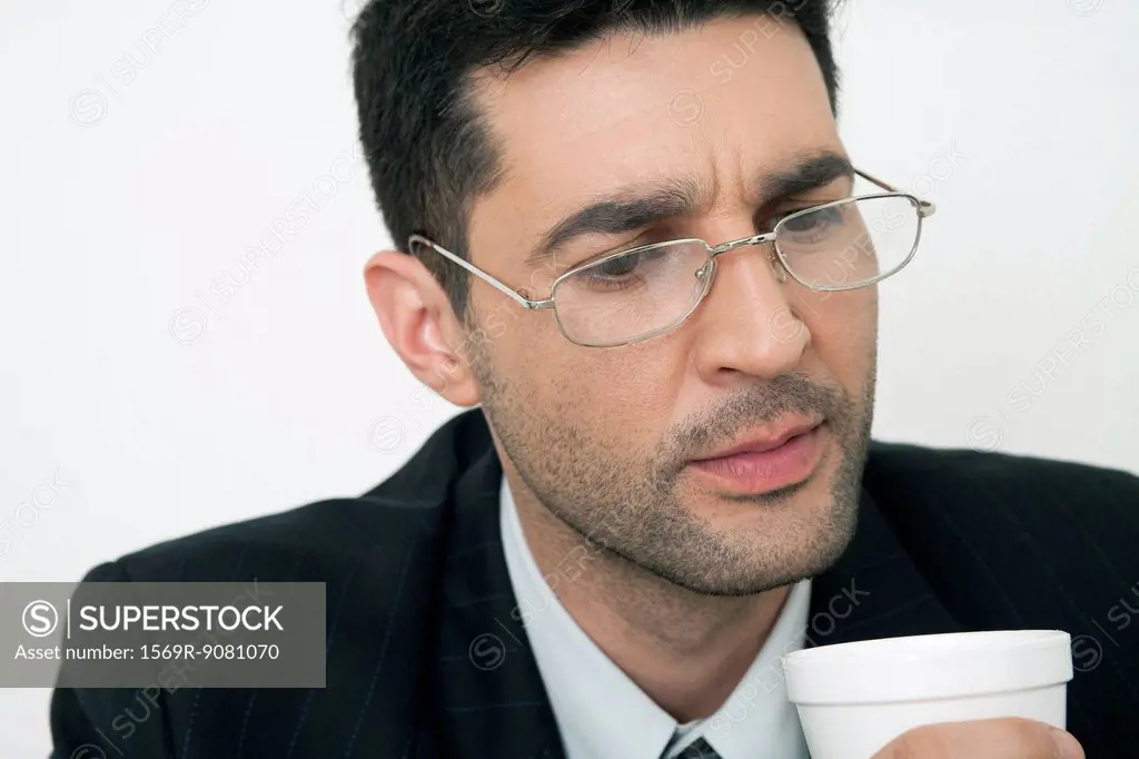Mid-adult businessman holding disposable cup