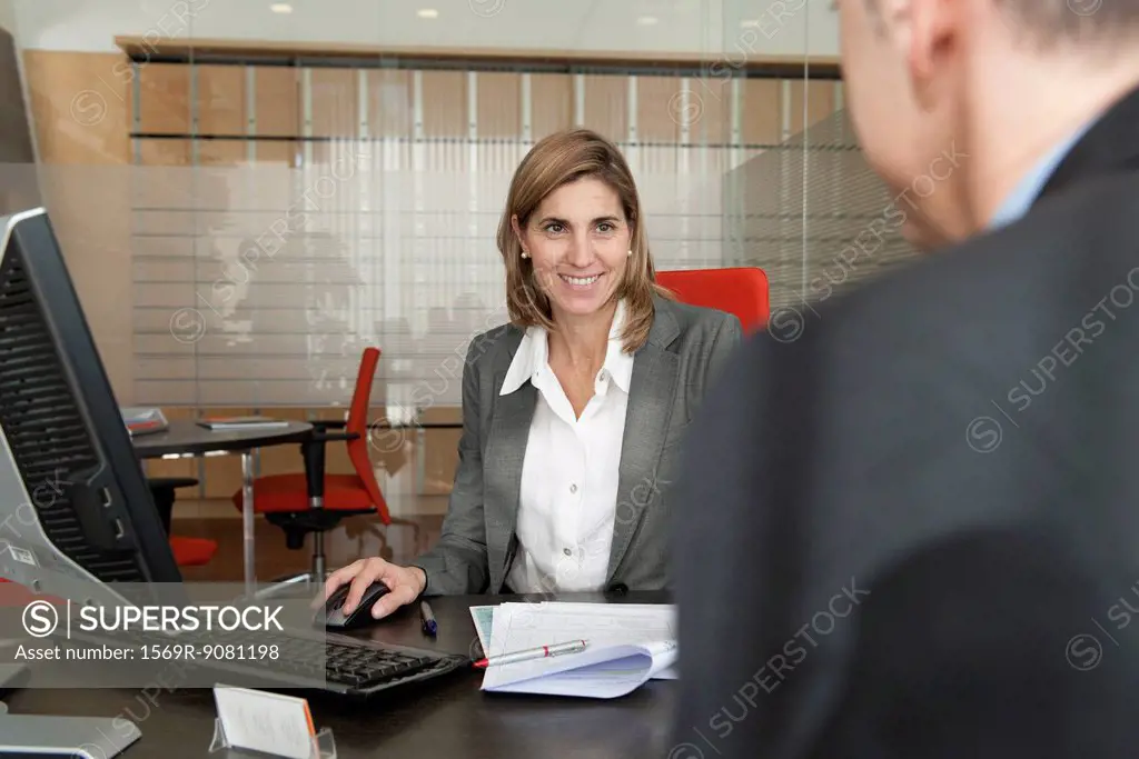 Businesswoman assisting client in office