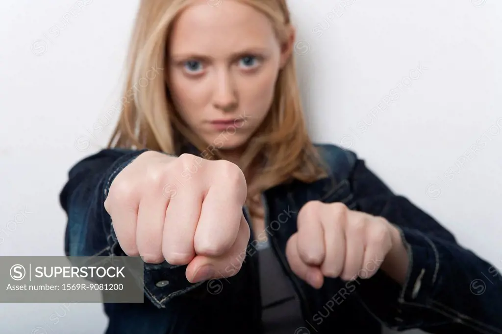 Young woman holding out clenched fists