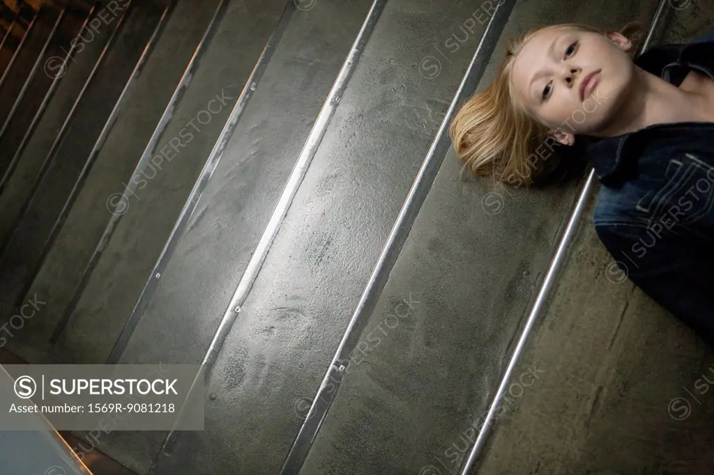 Young woman lying on stairs