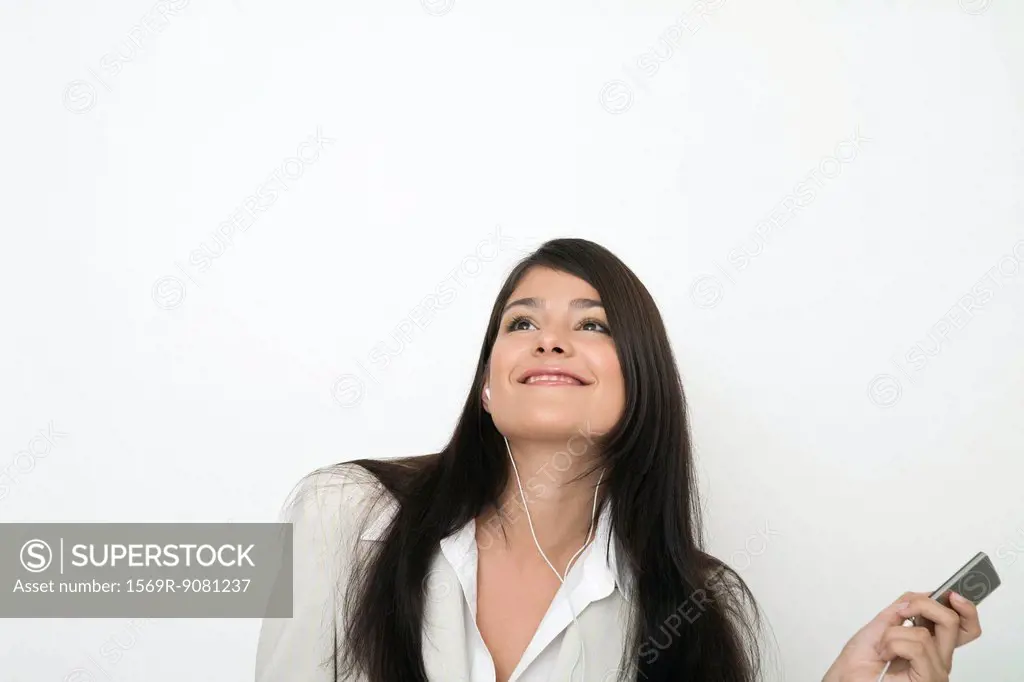 Young businesswoman listing to music on mp3 player