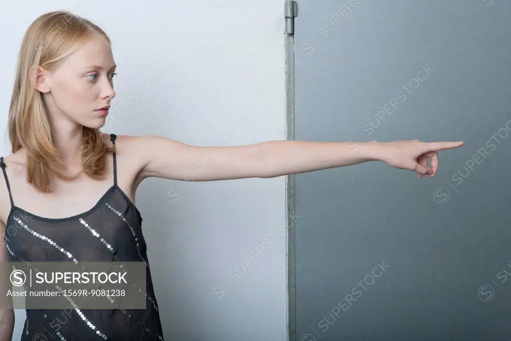 Young woman pointing and looking away