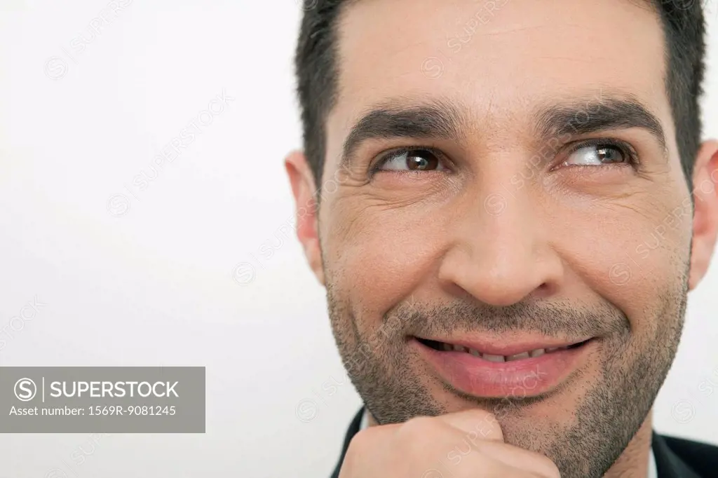 Mid-adult man daydreaming, smiling