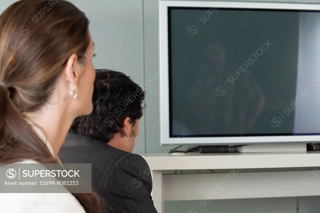 Colleagues watching television, side view