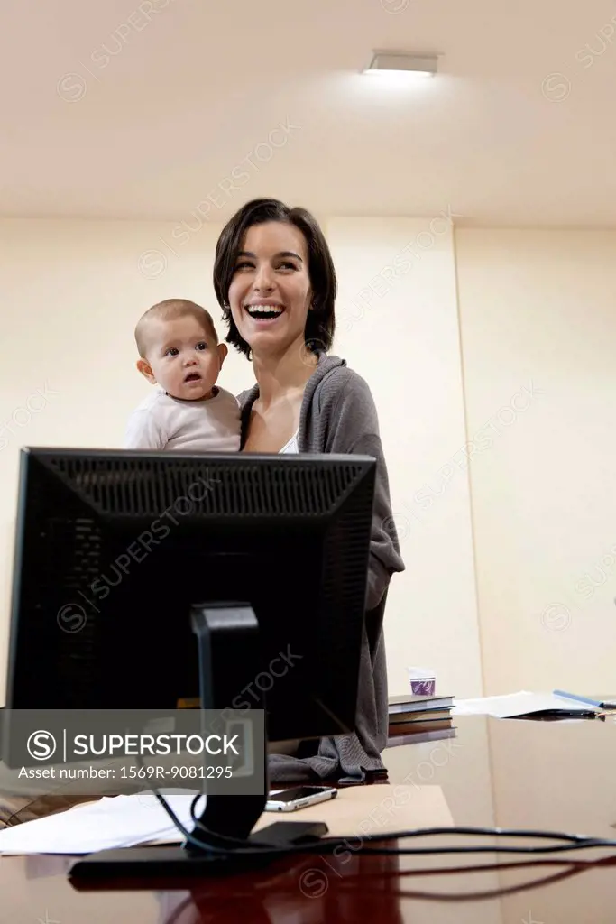 Mother holding baby in office